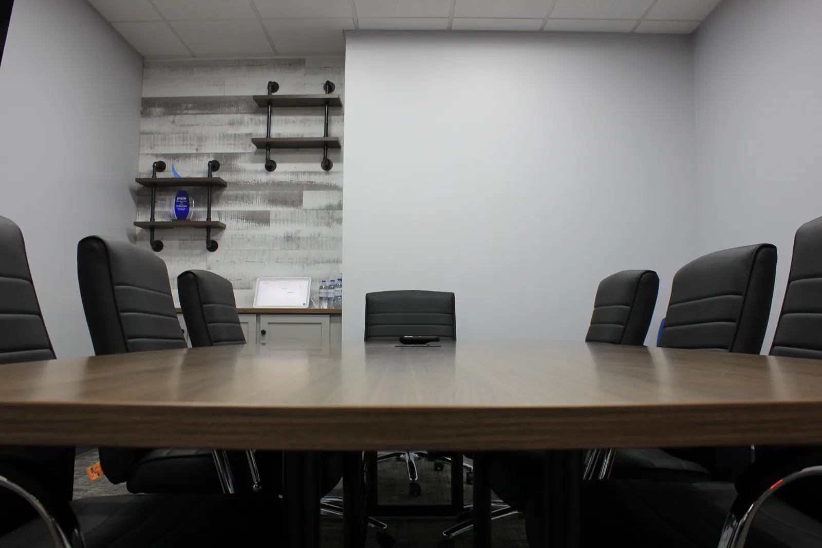 CTi Tech Plaza conference room with meeting table, black chairs and wood accent wall